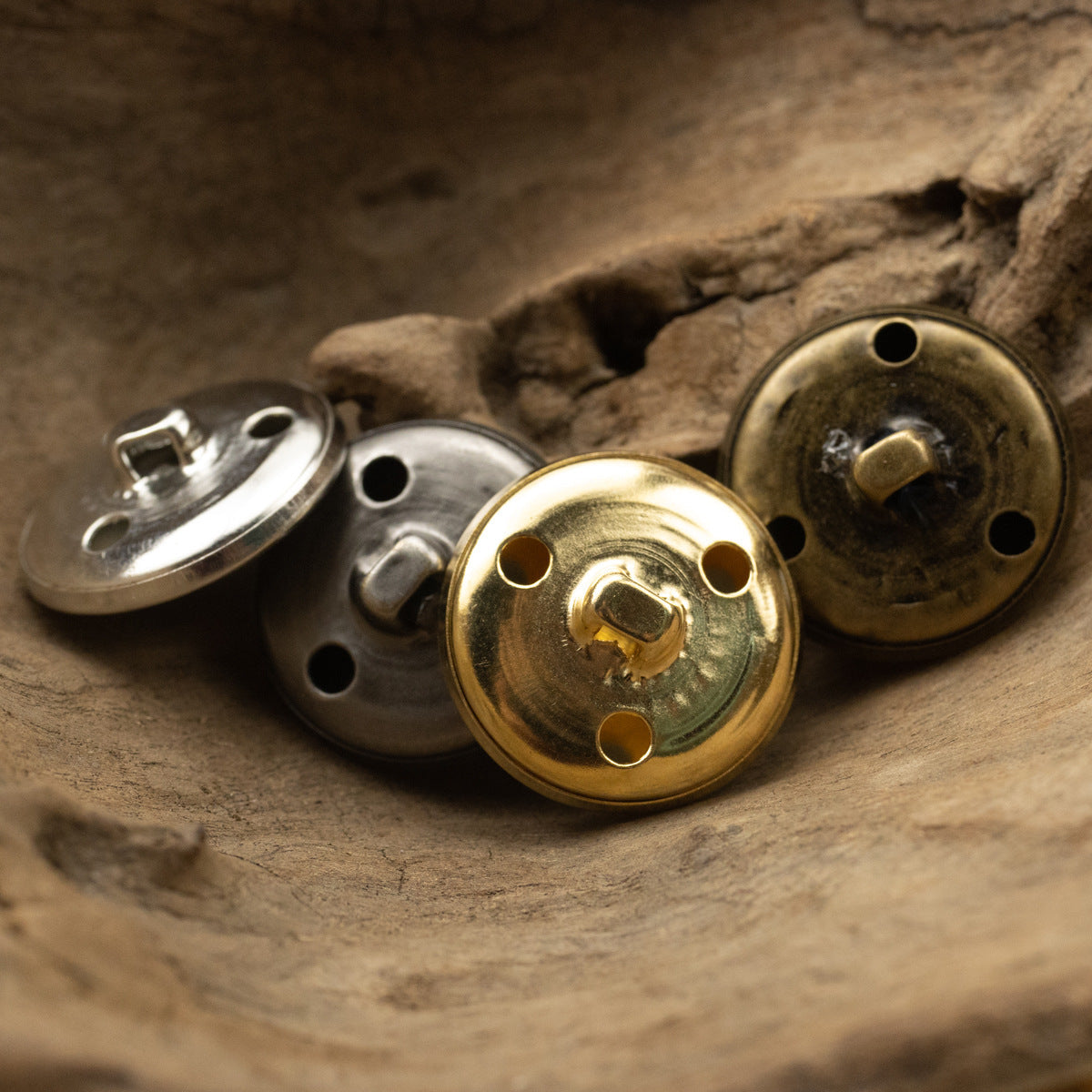 Round metal buttons with hollow shank backs; gold, silver, and antique bronze tones