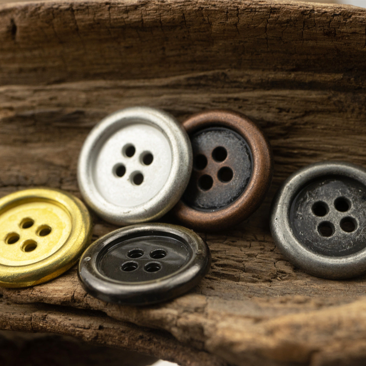 Assorted round 4-hole metal buttons in silver, bronze, and gold tones