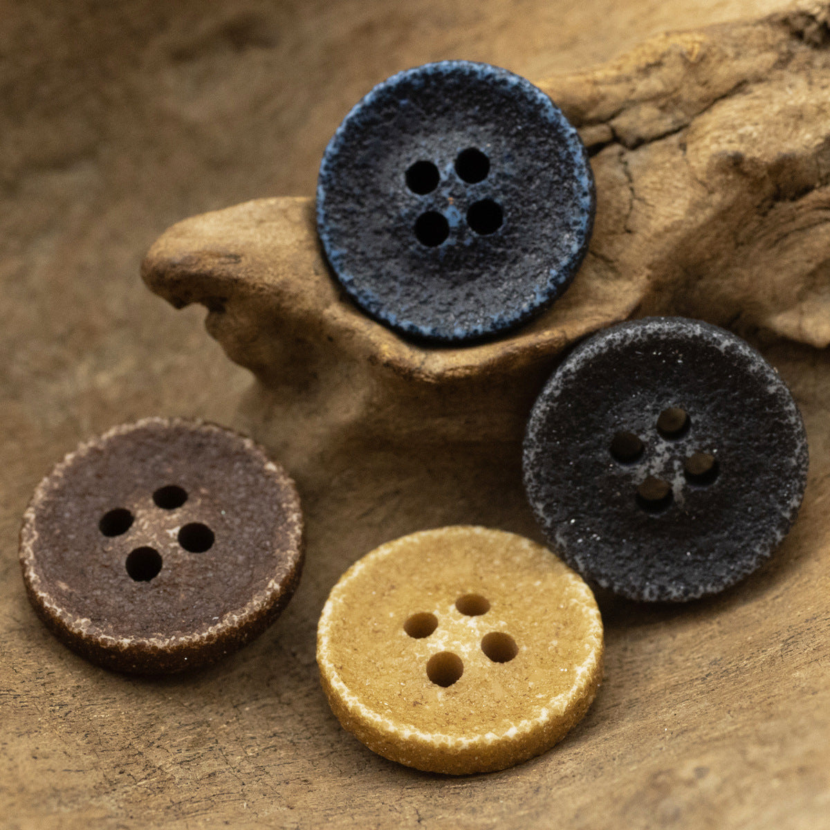 Deep blue distressed resin button, four holes and textured weathered finish.