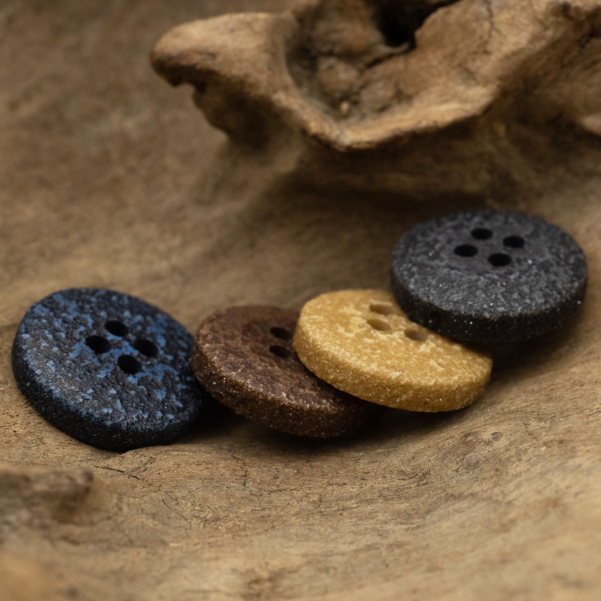 Distressed resin buttons in blue, brown, black and khaki, four-hole design.