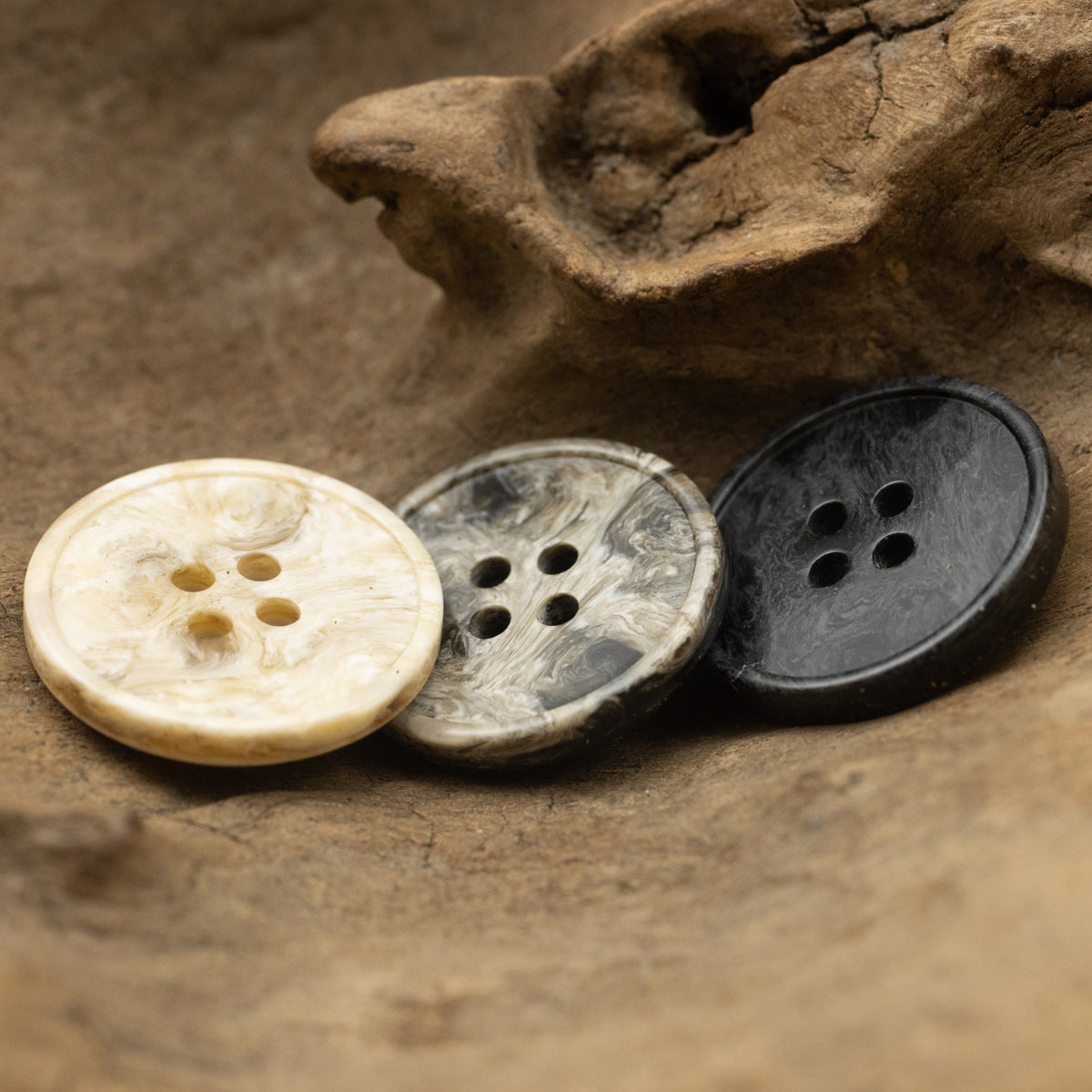 Marble-effect resin buttons, 4-hole, cream, gray, and black.