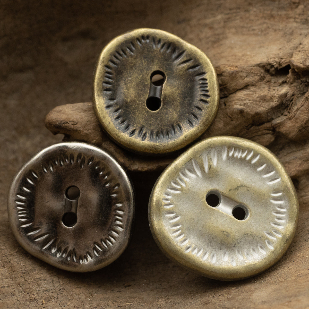 Set of antique zinc alloy 2-hole buttons with irregular edge, mixed finishes on wood