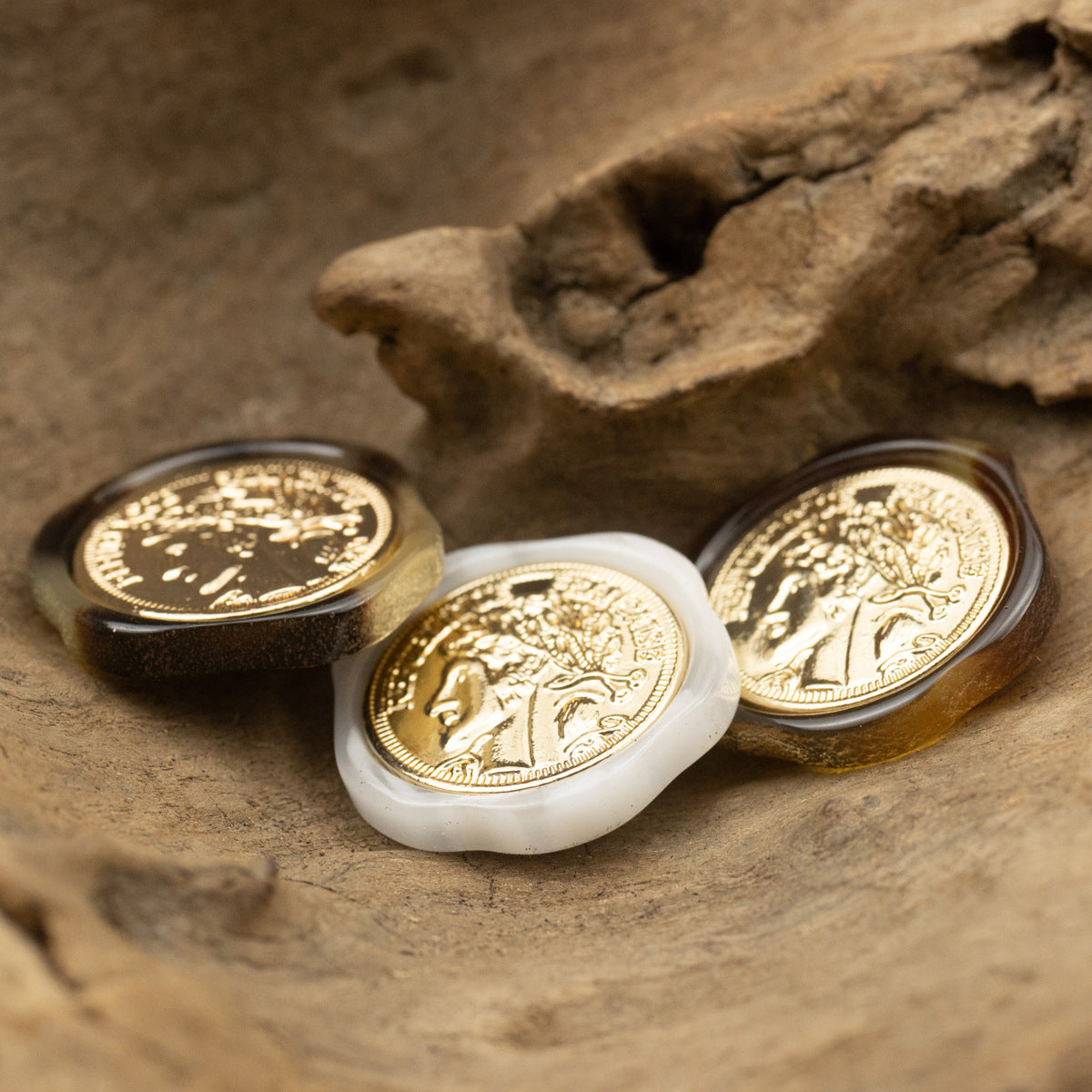 Irregular resin shank buttons, scattered view: white and dark tones with gold portrait