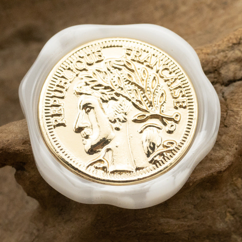 Irregular resin shank button, white translucent edge, gold portrait medallion