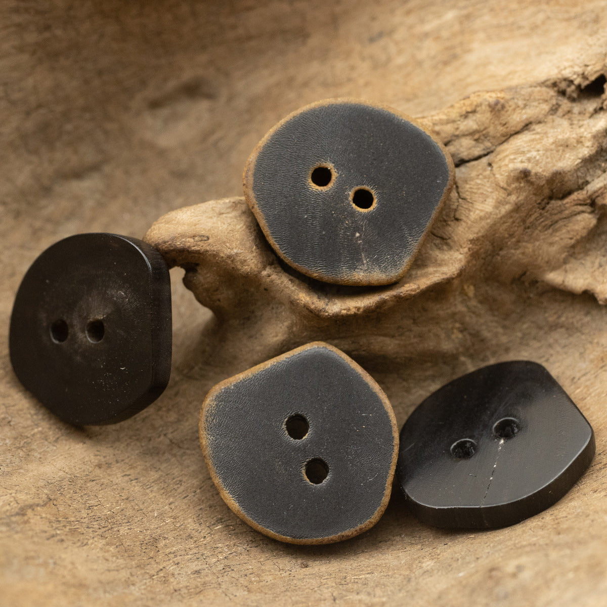 Set of dark irregular 2-hole horn buttons with vintage burned finish, 4pcs shown