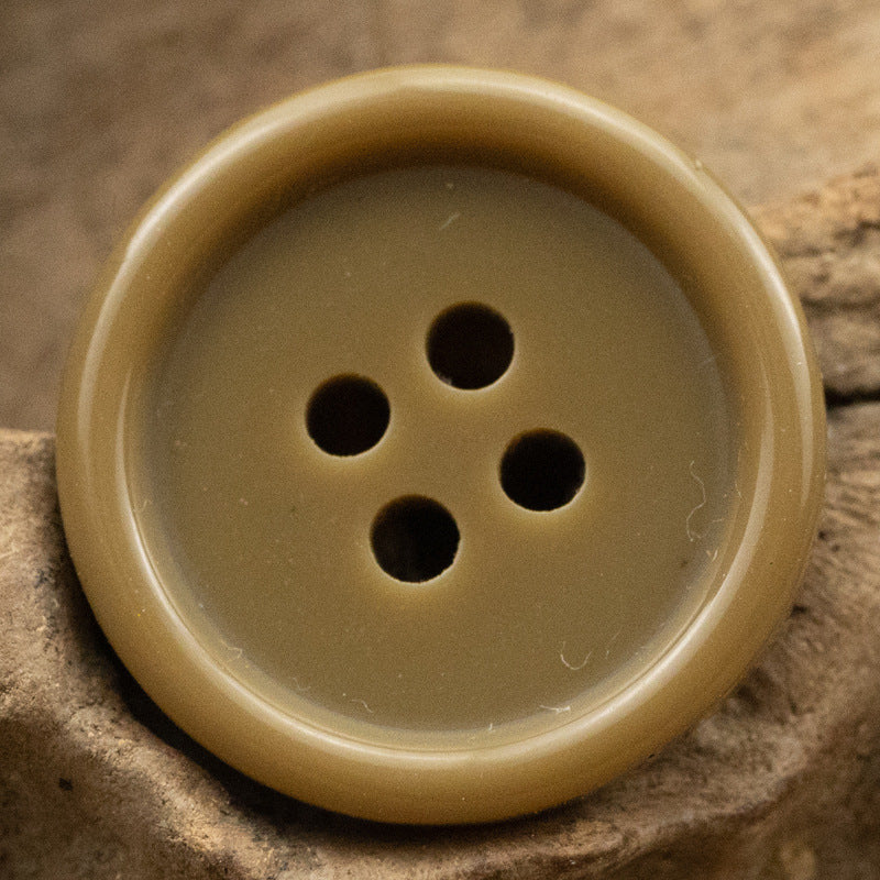 Beige resin suit button with four holes, solid color front