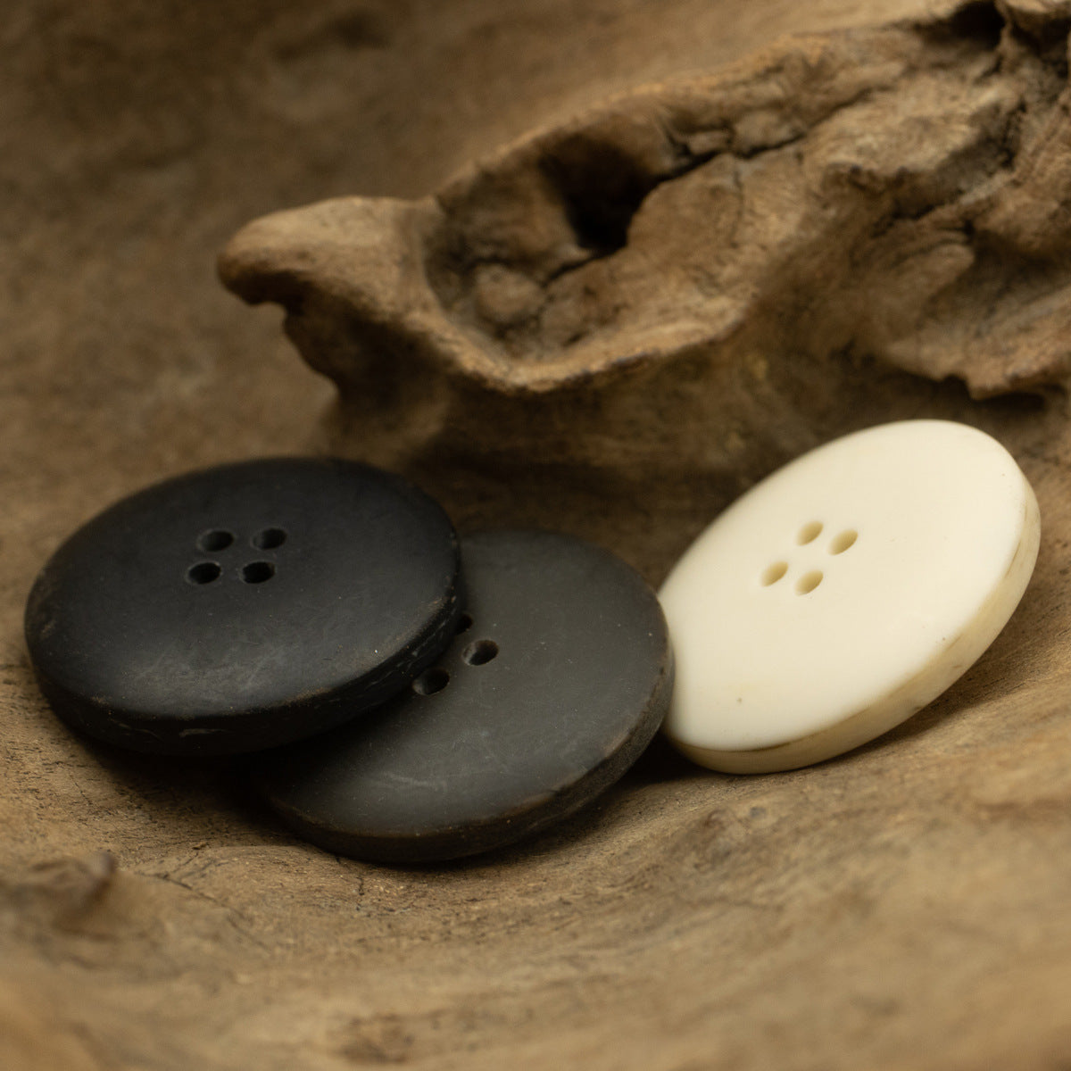 Matte four-hole resin buttons in dark gray and milk white, bowl-shaped