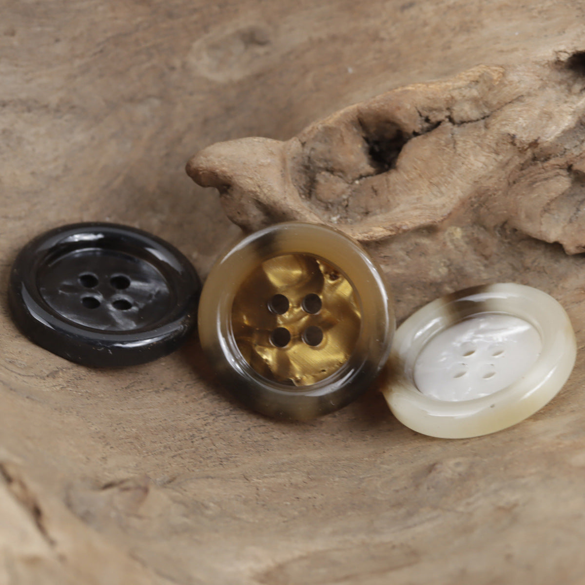 Assorted round 4-hole imitation shell buttons: black, gold-amber, and white (3 shown)