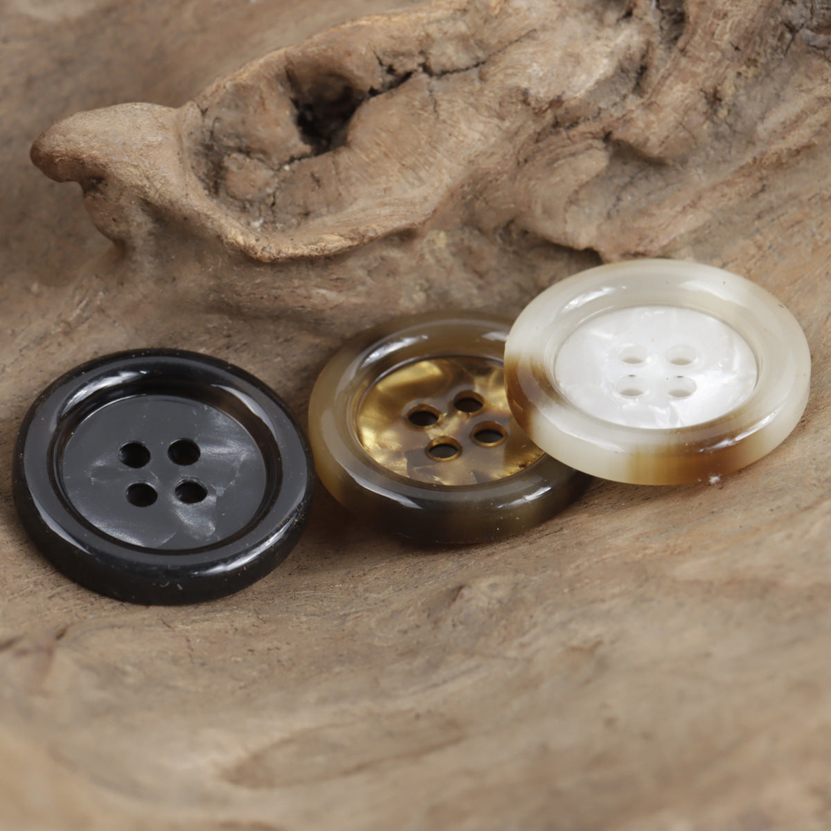 Round 4-hole imitation shell buttons in white, dark gray/black, and gold-amber (3 buttons)