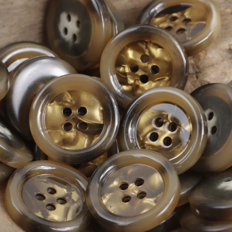 Assorted round 4-hole imitation shell buttons in clear white, gold-amber, and dark tones
