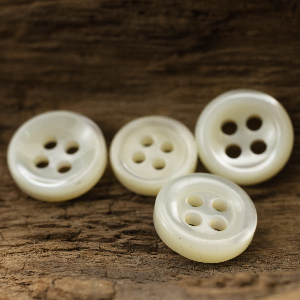 Mixed beige 4-hole shell buttons, round front view