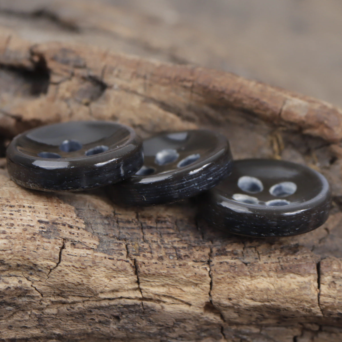 Dark blue shell buttons, thick 11.5mm, four-hole design laid on wood