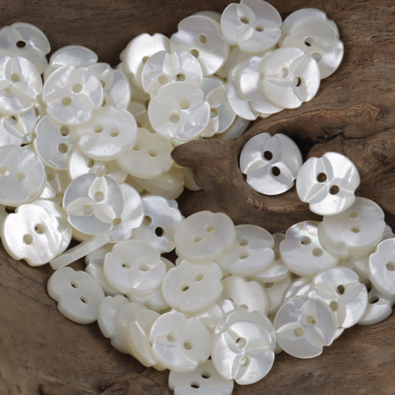 Natural white maple leaf-shaped shell buttons, two-hole fronts in assorted pile