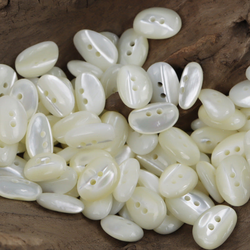 Irregular oval shell buttons, light cream to pale yellow, 2-hole (10 pcs)