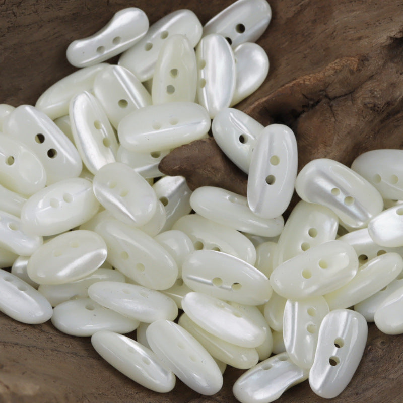 Irregular oval white shirt buttons with 2 holes, glossy shell look (10 pcs)