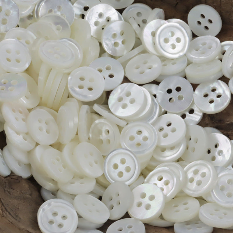Round white shell shirt buttons with four holes, natural finish