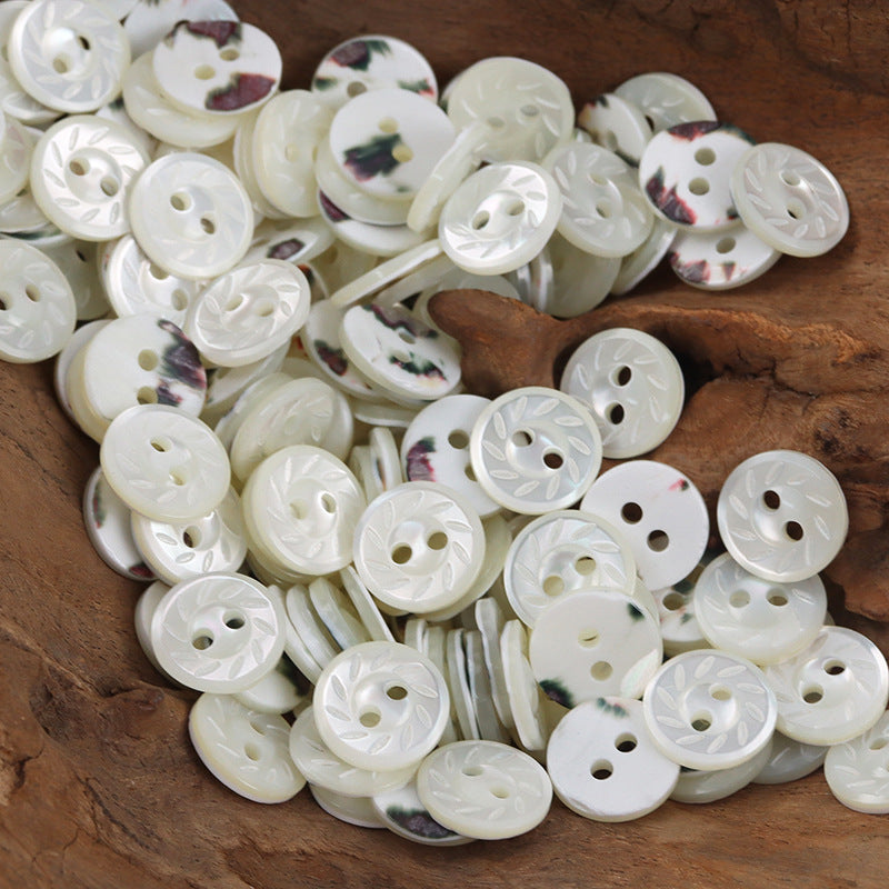 Floral marbled white shell buttons, round 2-hole, glossy finish with varied embossed details