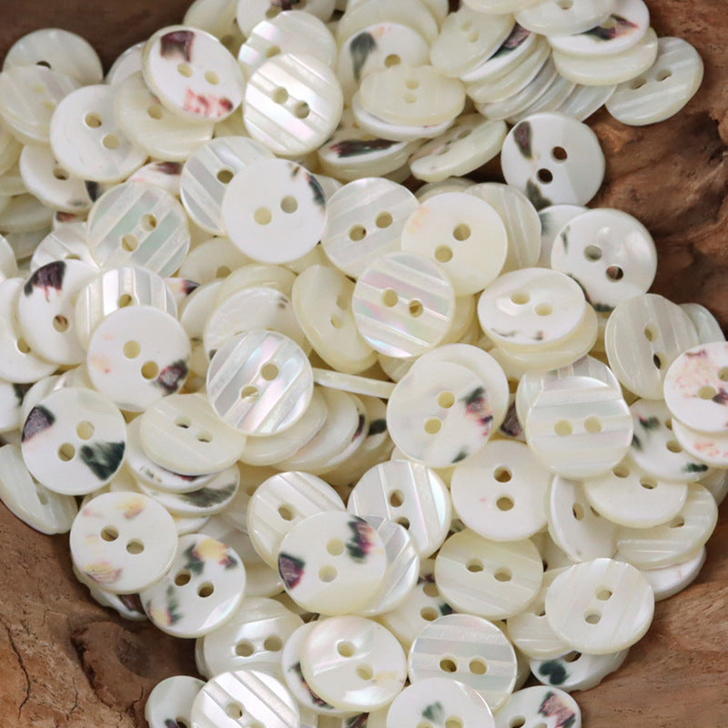 Assorted cream-white shell shirt buttons with floral veining, multiple hole styles