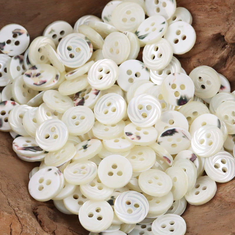 Assorted cream-white shell shirt buttons with multihole fronts and veining