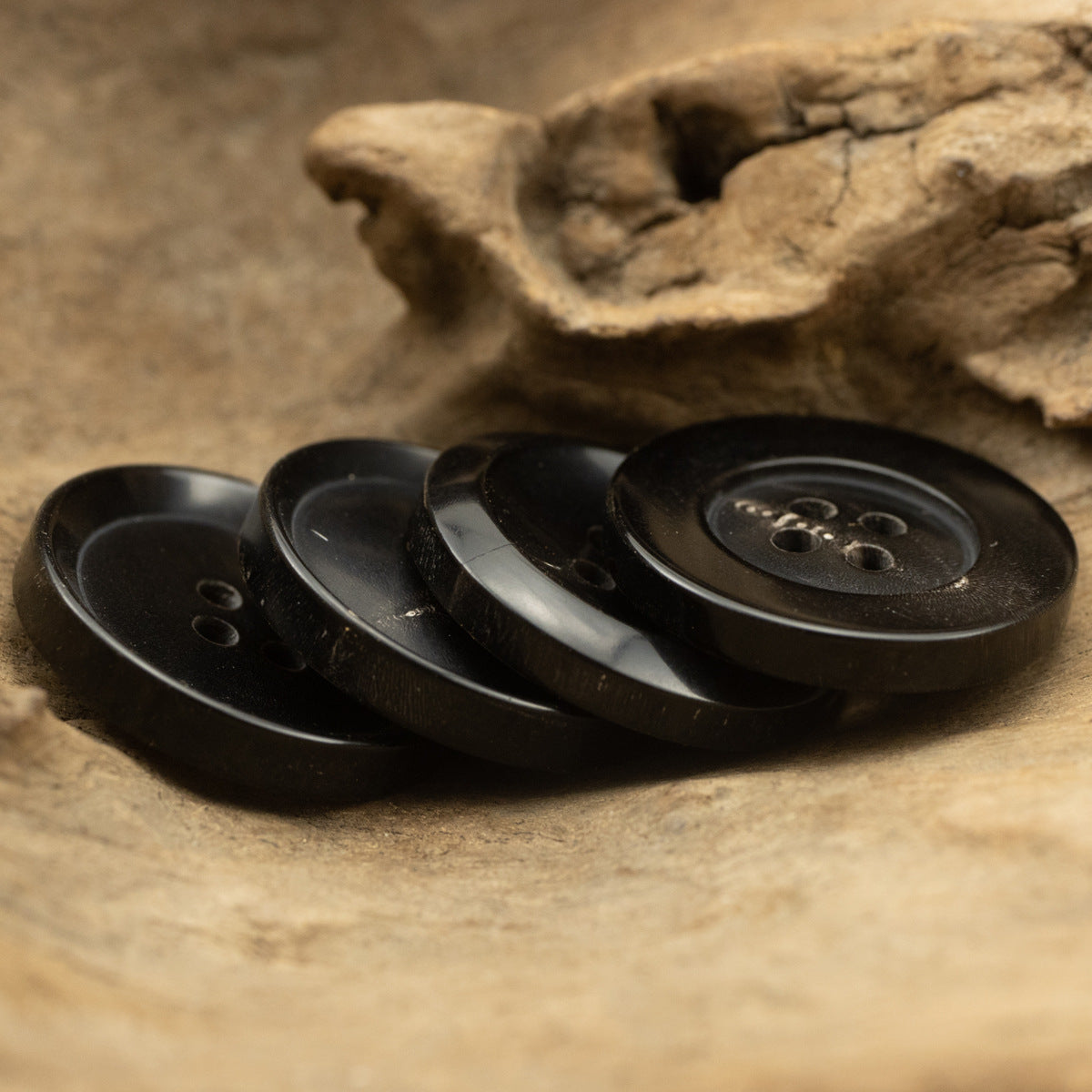 Black 4-hole buttons laid in a row, horn-style look
