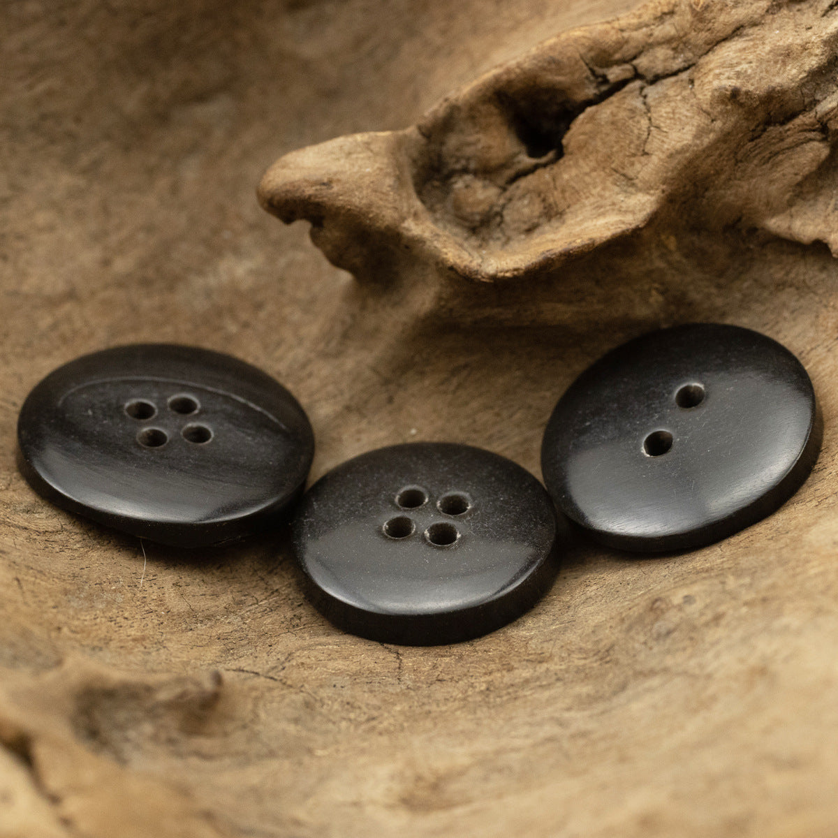 Black rough horn buttons with 4 holes, round face, dark mottled finish