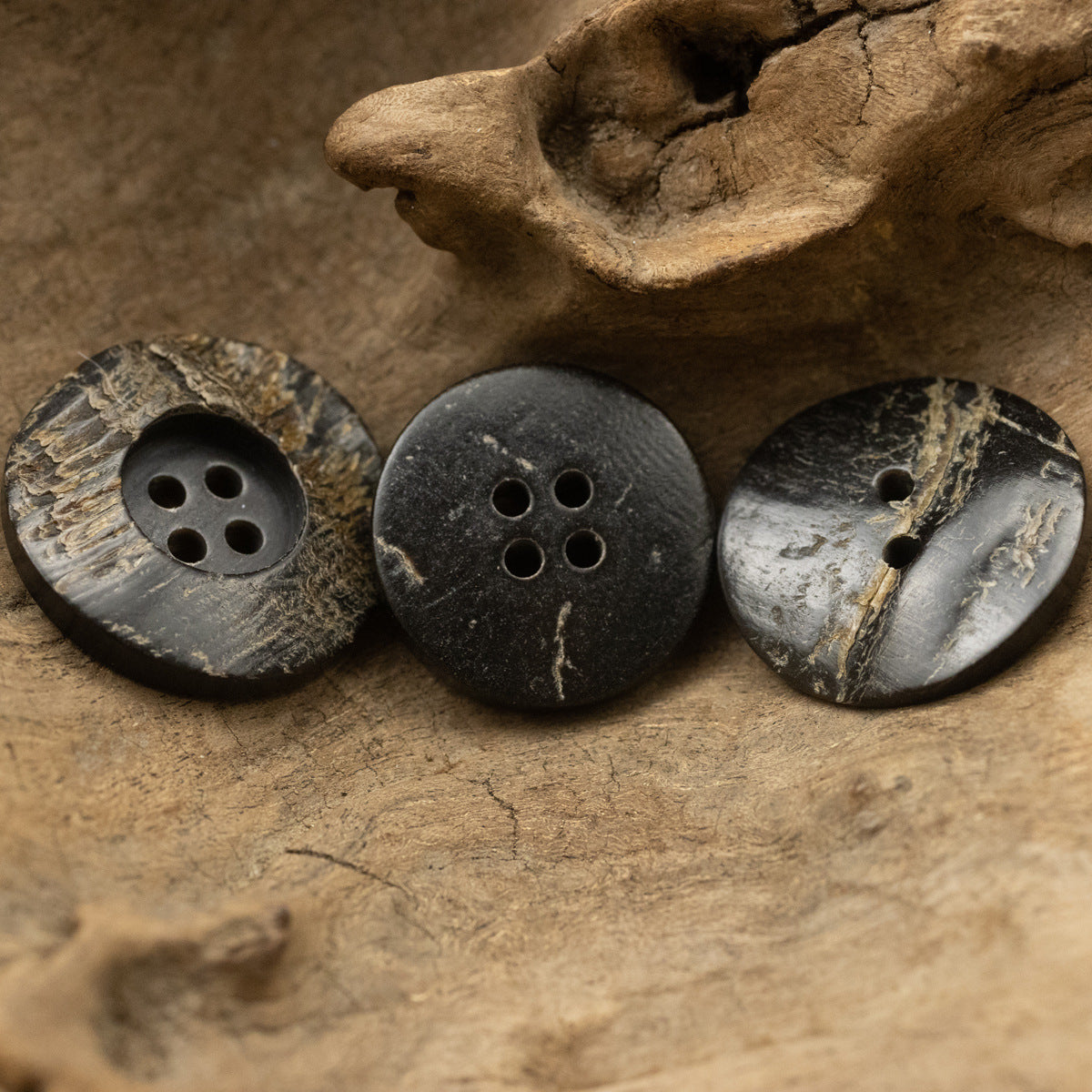 Black rough horn buttons, round shape, each with 4 holes and visible natural texture