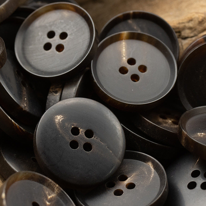 Matte vintage black horn buttons, 4-hole, 15–25mm, several buttons in view