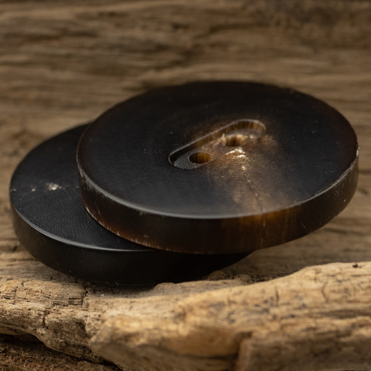 Flat two-hole horn button, matte dark black, side view (15–28mm)