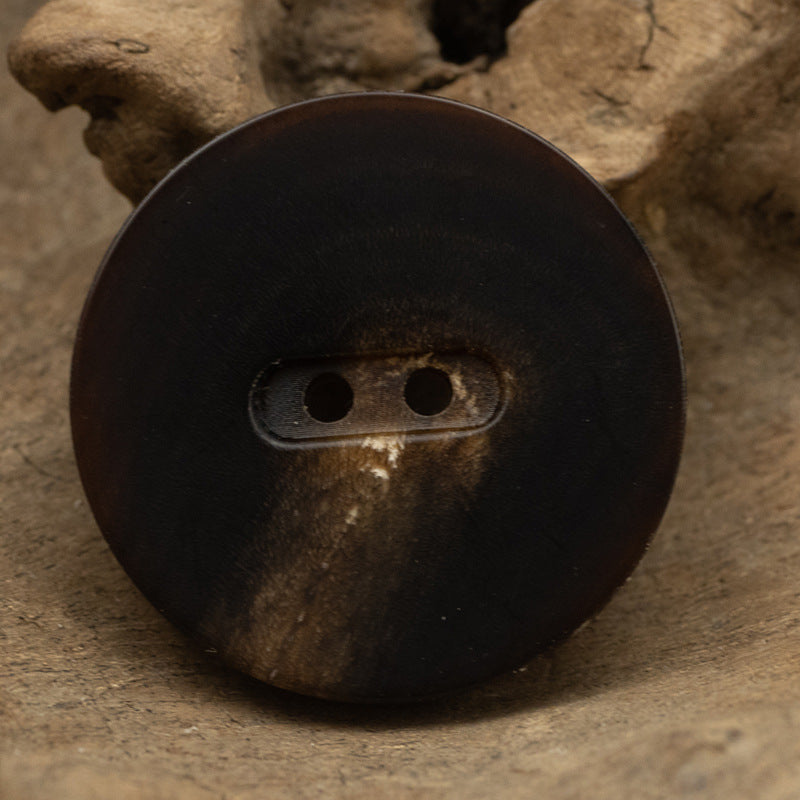 Matte brown flat two-hole horn button, close-up, 15–28mm
