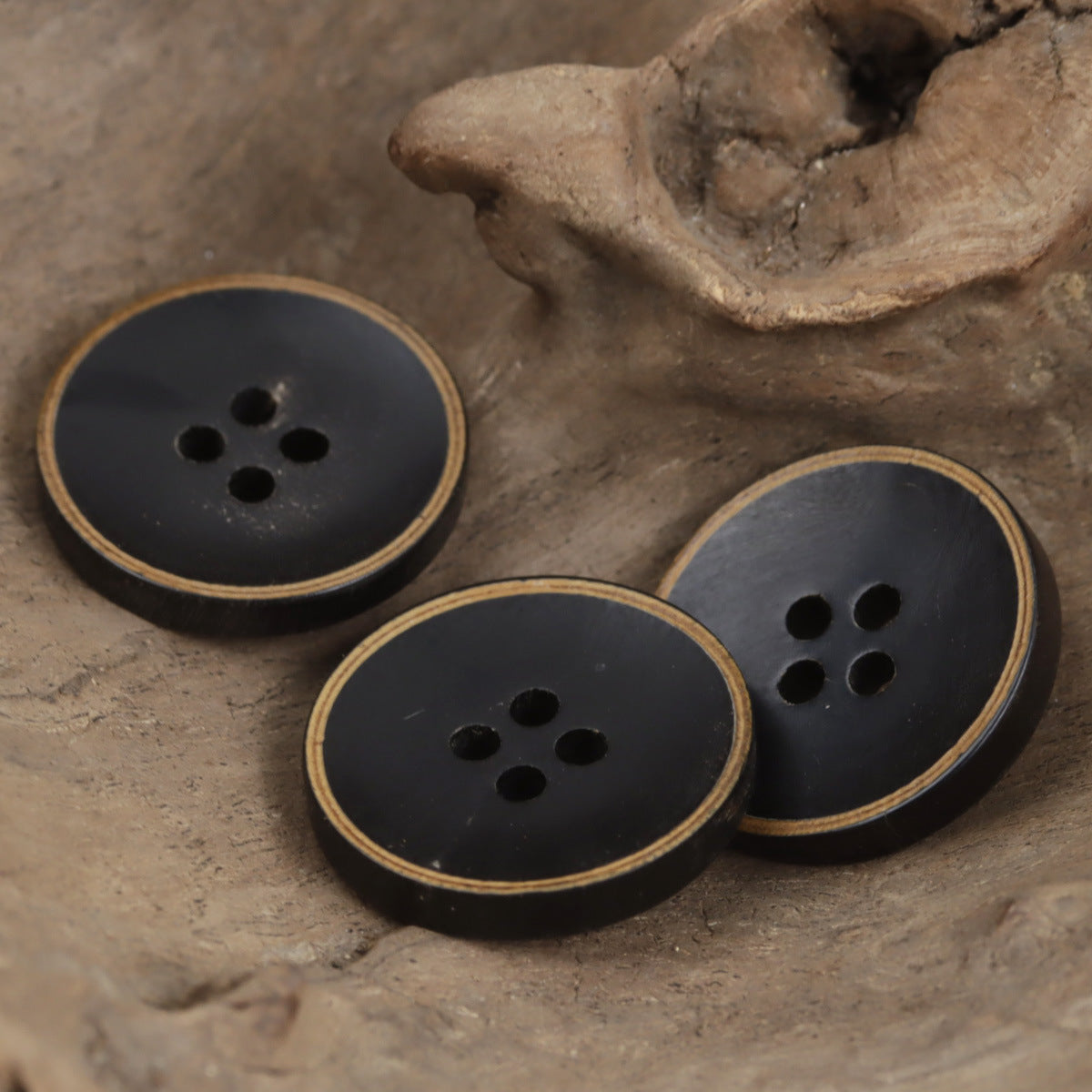 Four-hole horn bowl buttons, dark finish with gold rim, four-button group