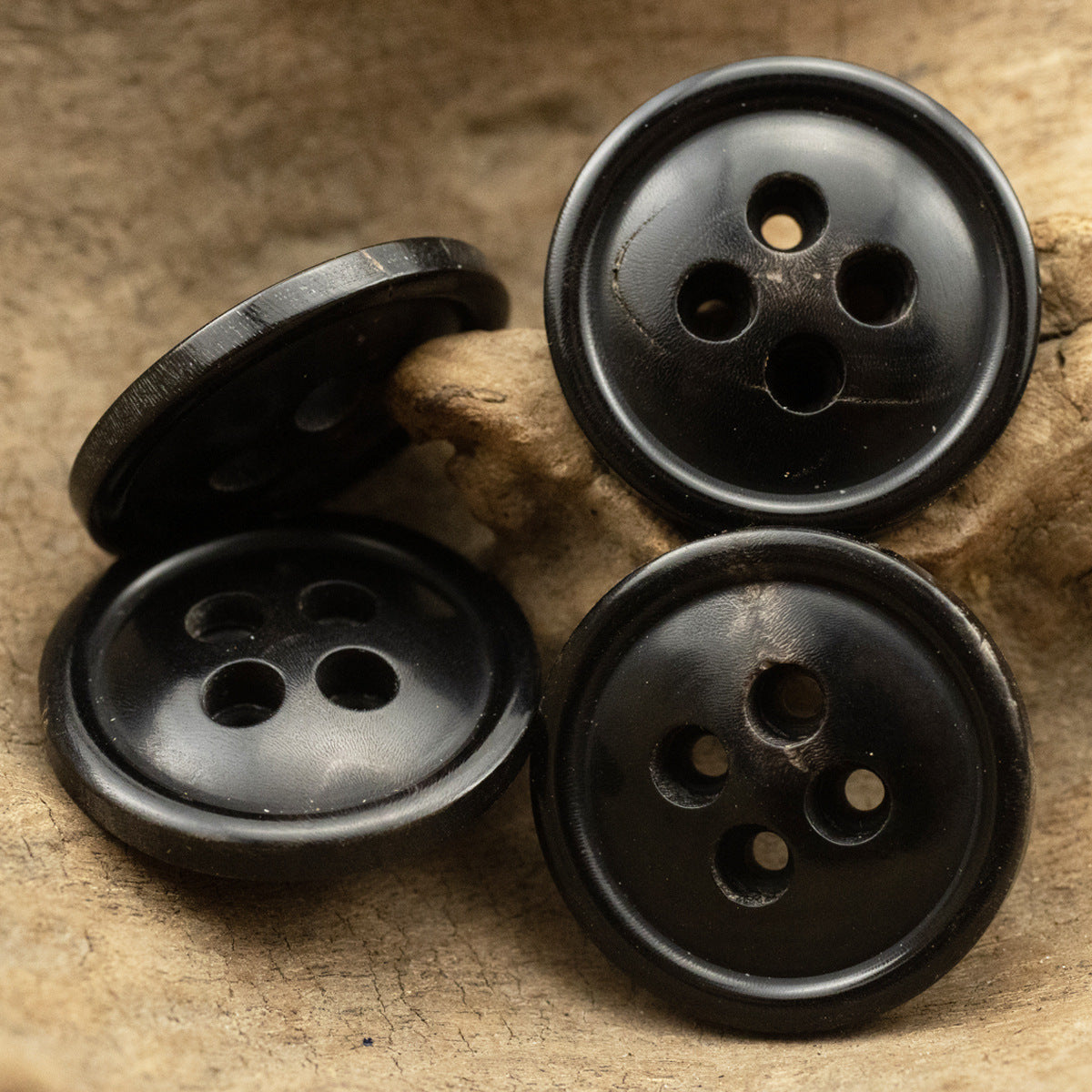 Set of three black horn buttons, round 4-hole style