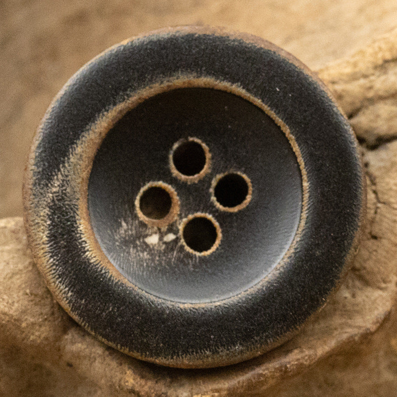 Burnt black coat button, four-hole front, antiqued look, slim edge rim