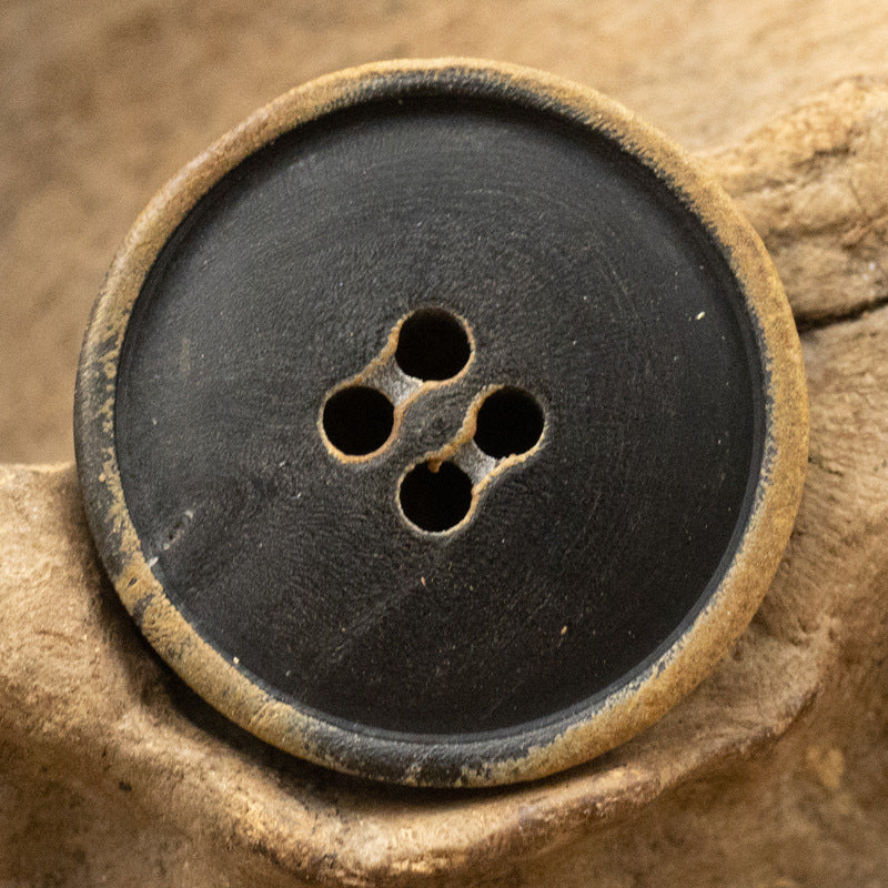 Antiqued burnt black coat button, four-hole design, rough texture, wide edge ring
