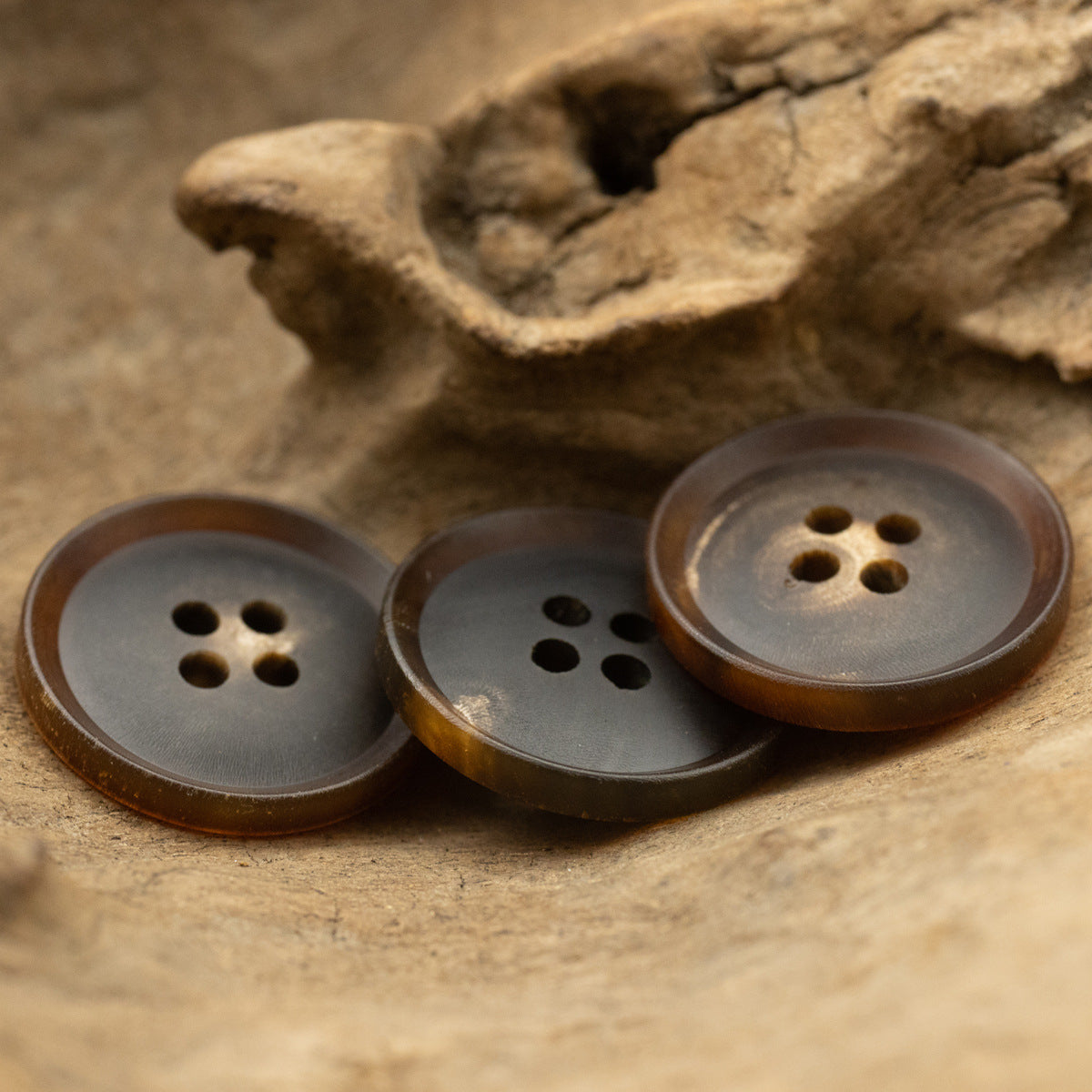 Dark brown horn buttons set, round backs with central shank holes