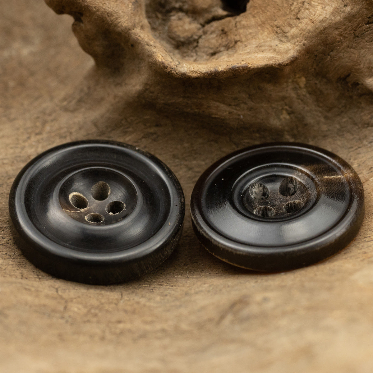 Vintage 4-hole horn buttons, black, 15–25mm, front view of 2 pcs
