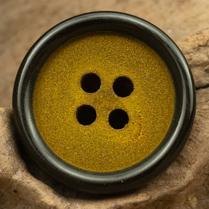 Ginger Yellow frosted horn button, close-up of four holes and dark edge