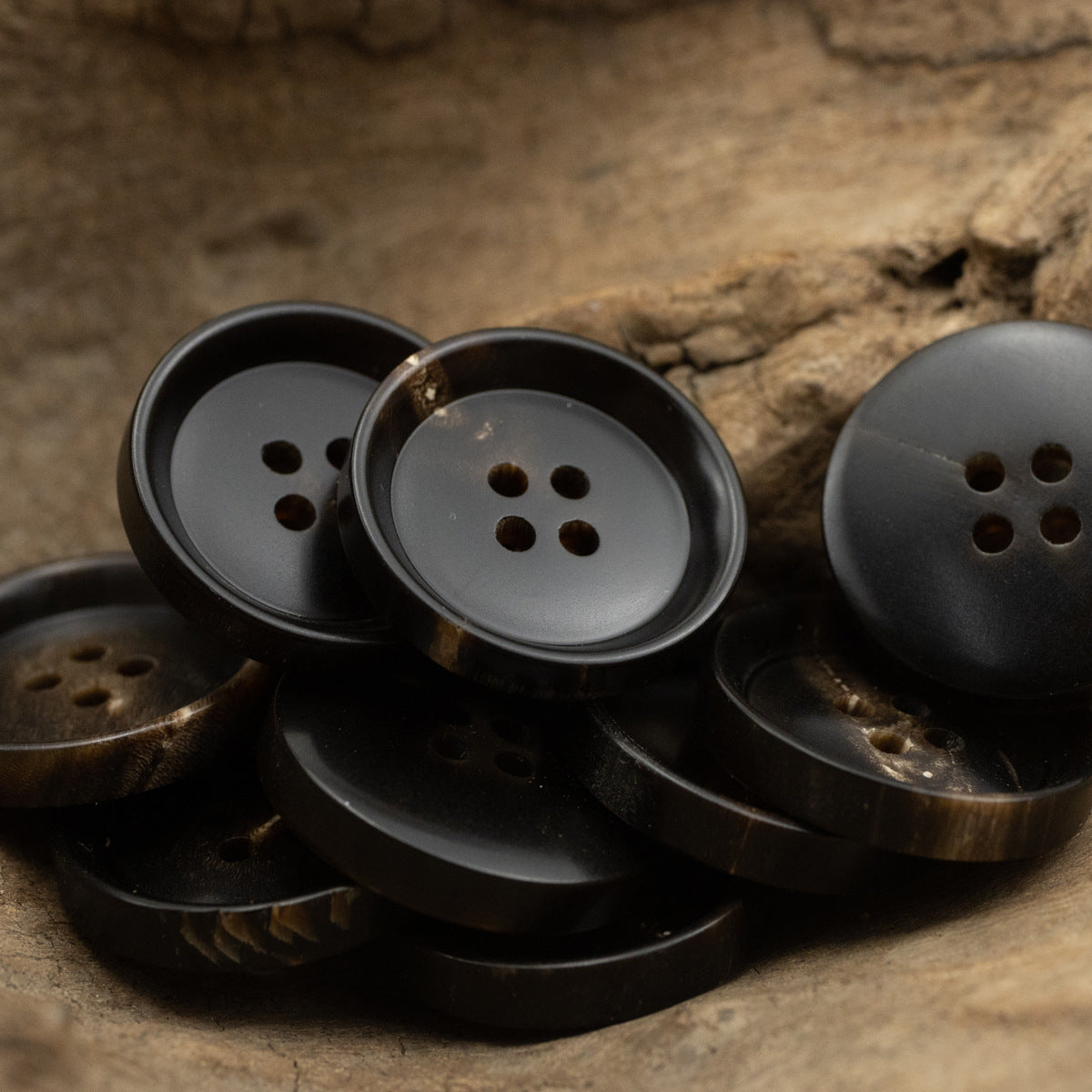 Cluster of black round 4-hole buttons, pan-shaped faces with four holes