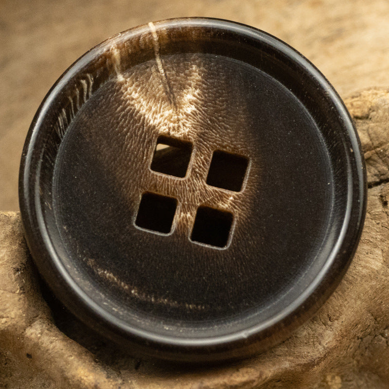 Coffee square-holed horn button, close-up front with four square holes