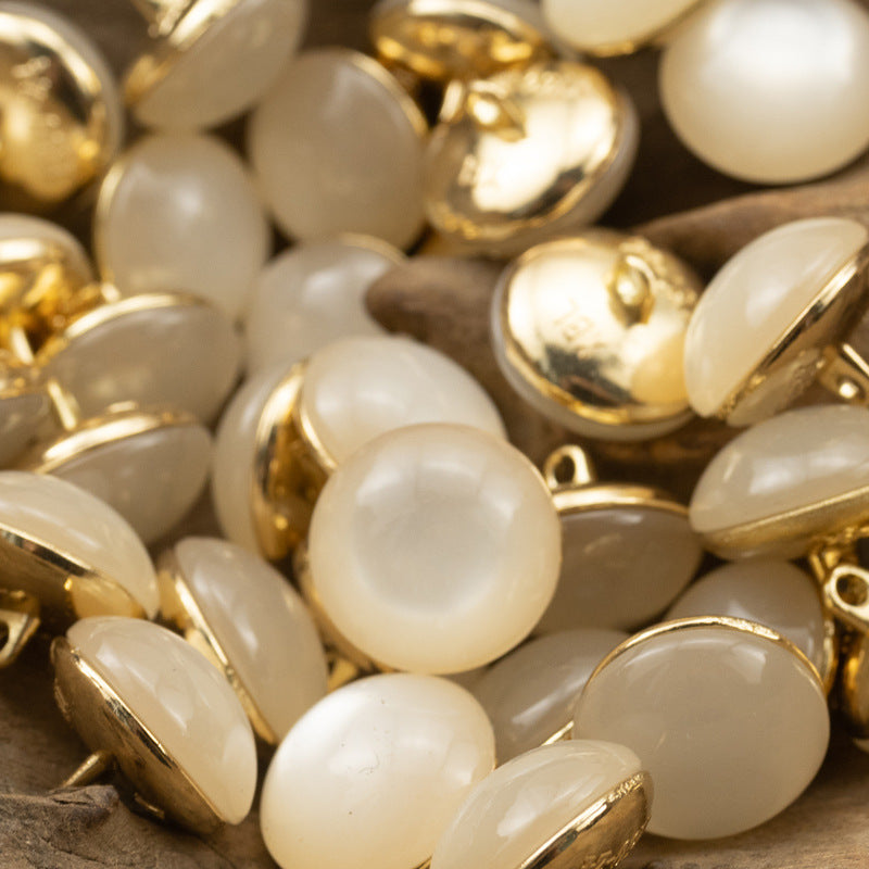 Pearl white round buttons with gold metal shanks, stone-look glossy finish
