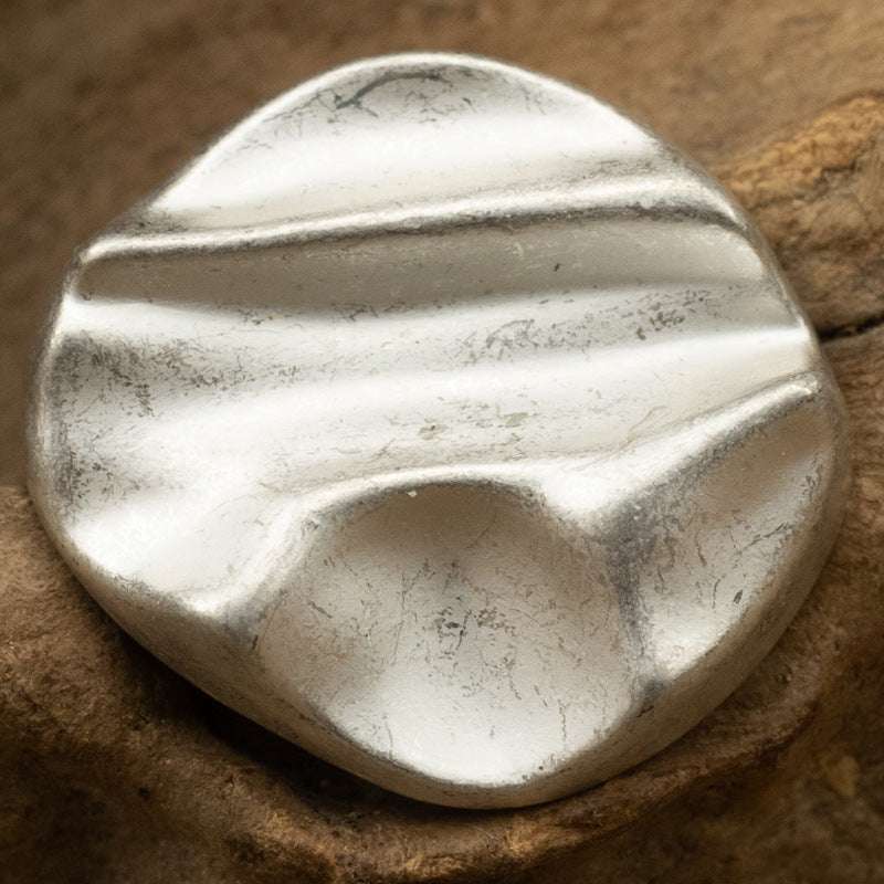 Matte geometric metal shank button in silver tone, rounded with diagonal stripe relief