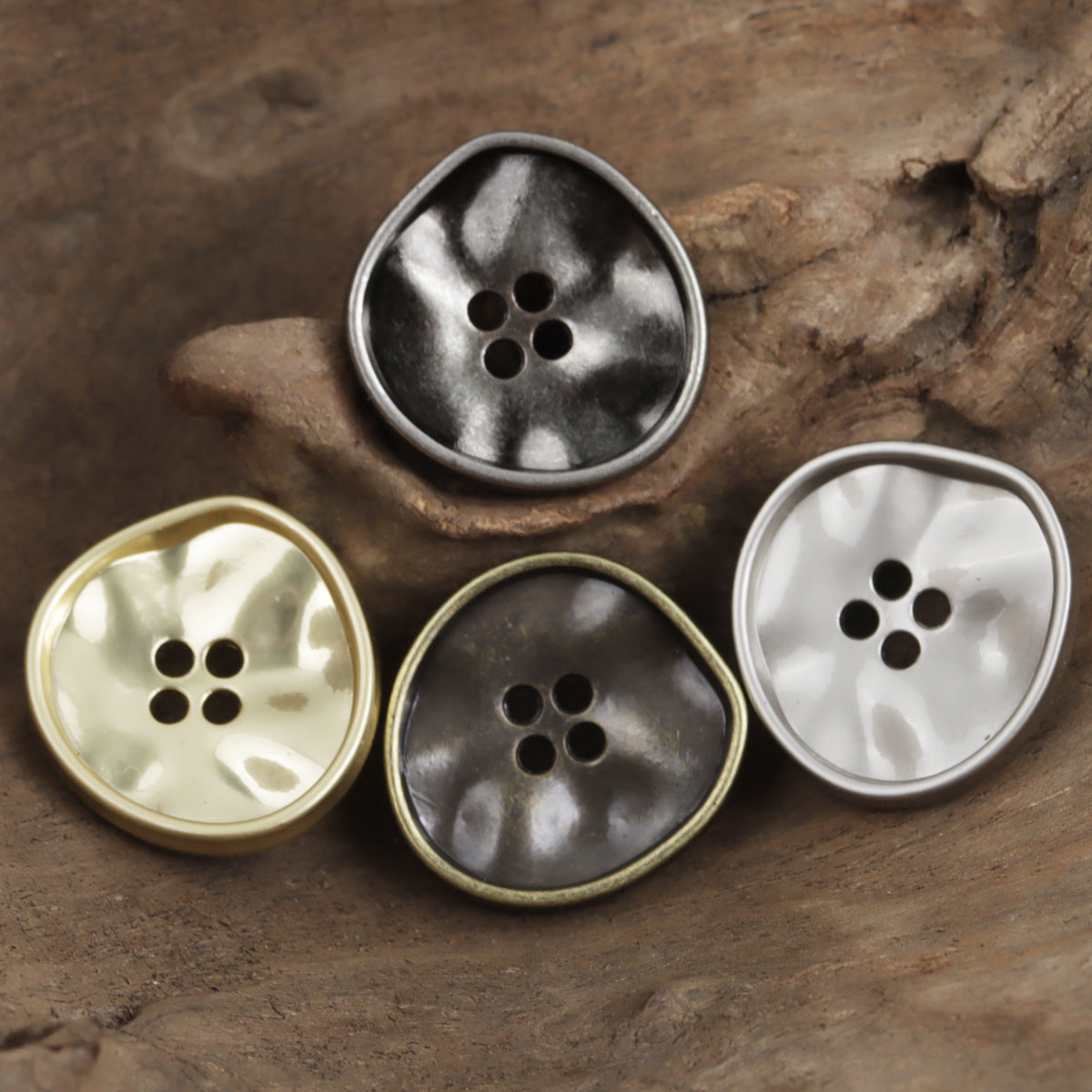 Four-hole metal triangle buttons in black, gold, dark silver, and white finishes