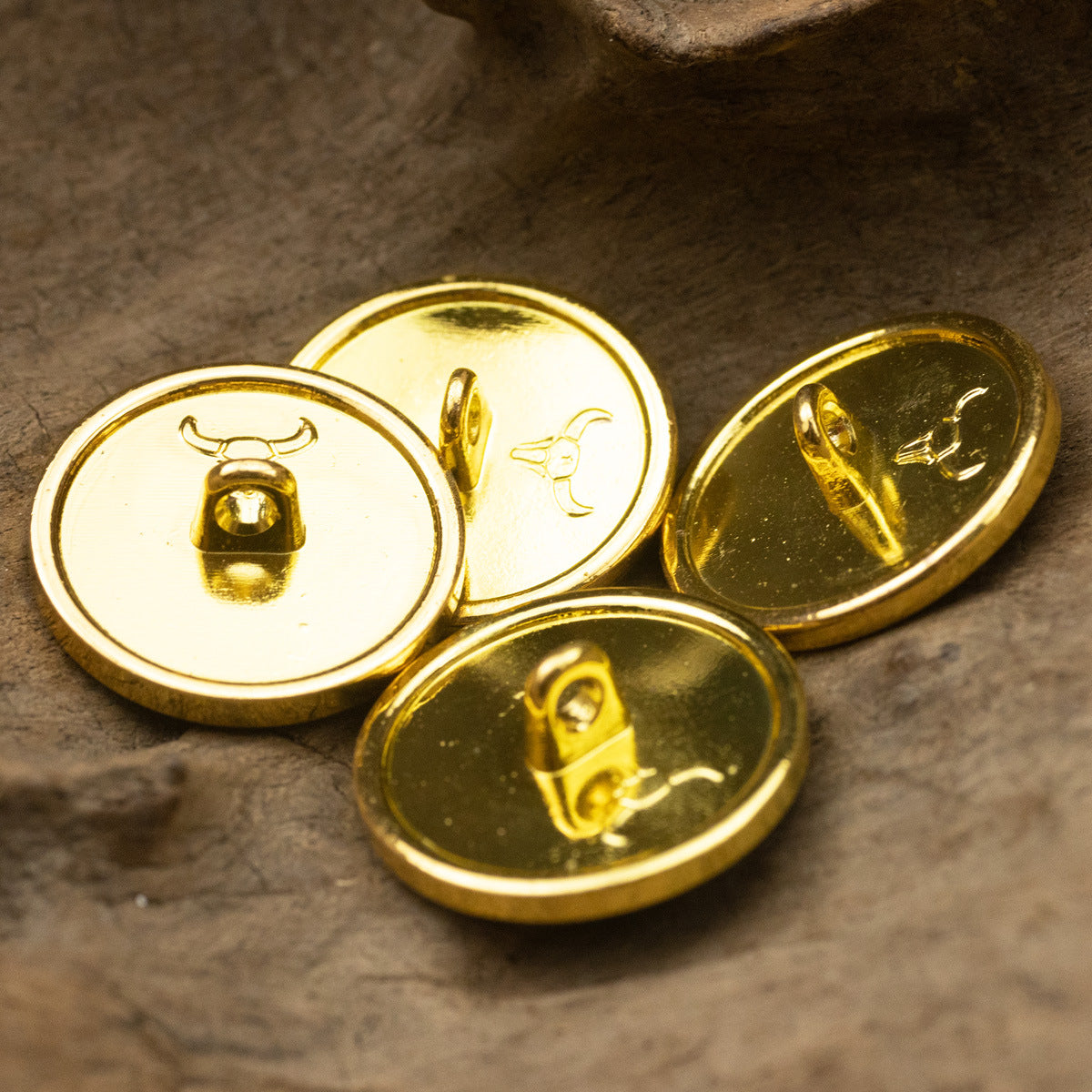 Metal shank buttons with gold emblems and dotted gold trim; three-button close-up
