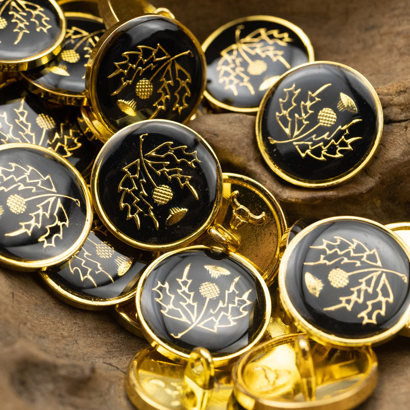 Metal shank buttons with gold camellia leaf and acorn motifs; dark glossy fronts with trim