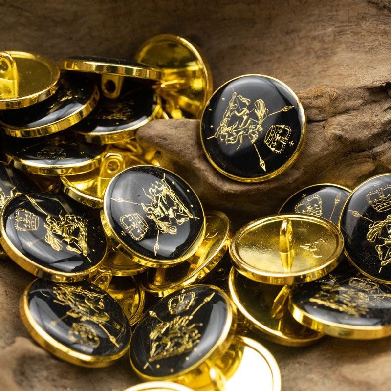 Metal shank buttons with gold crown/horse and sailboat motifs; dark glossy close-up