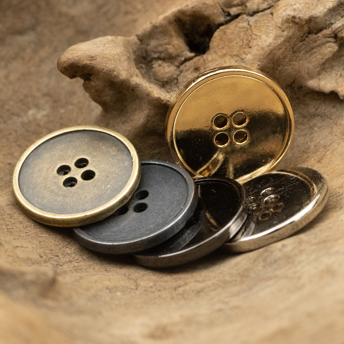 Round 4-hole metal buttons in gold, silver, and dark finishes, close-up assortment