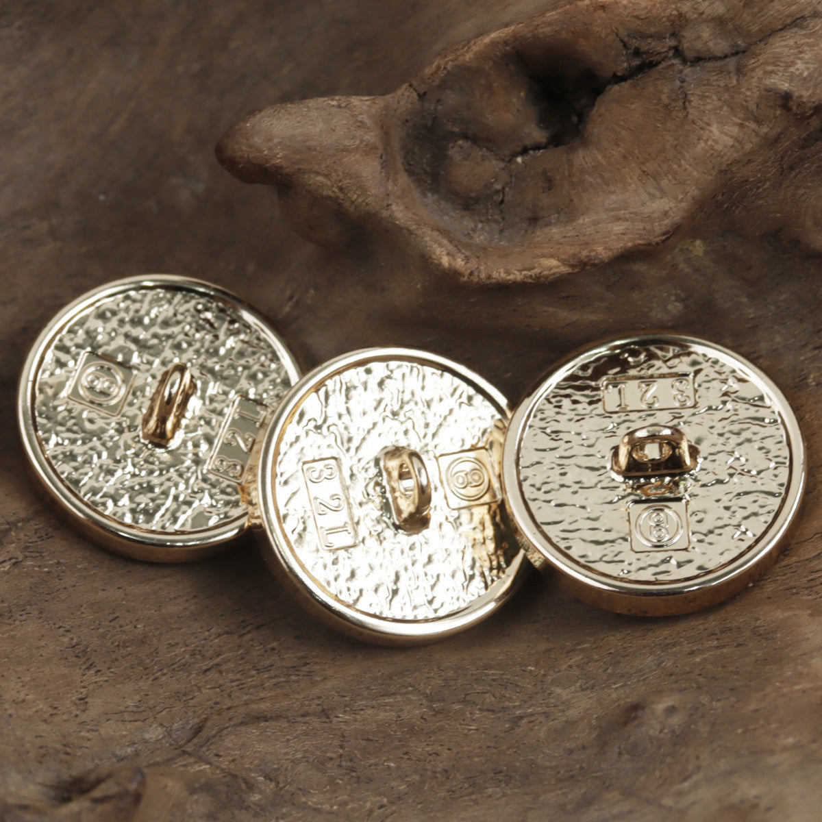 Set of round metal buttons with embossed patterns and central clasp