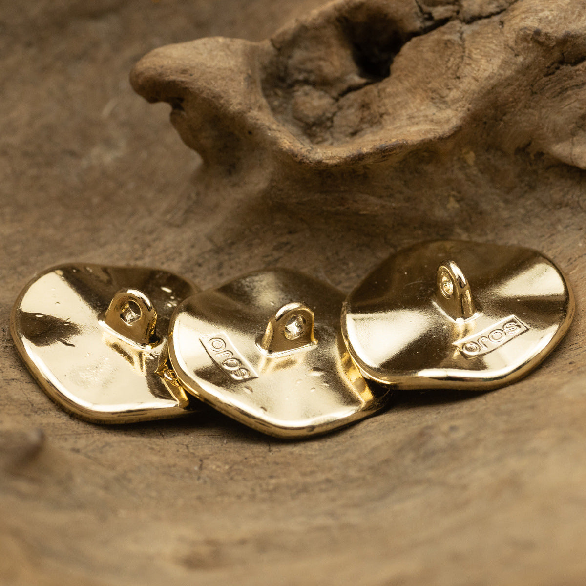 Curved coat buttons, gold metal shank backs with attachment loops