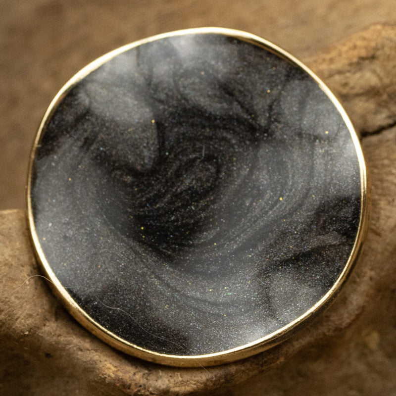 Curved irregular pearl coat button, dark/black front with gold rim