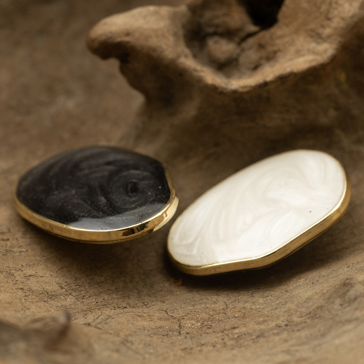 Irregular oval pearl buttons, black and white glossy finish with gold metal edge.