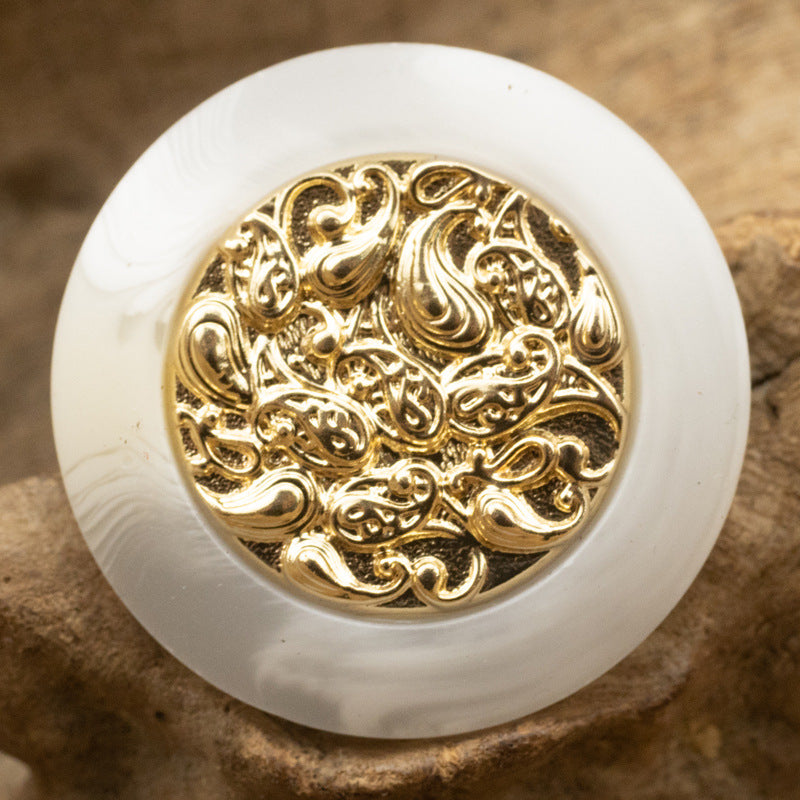 White resin button with gold cloud-style metal center, decorative swirl pattern